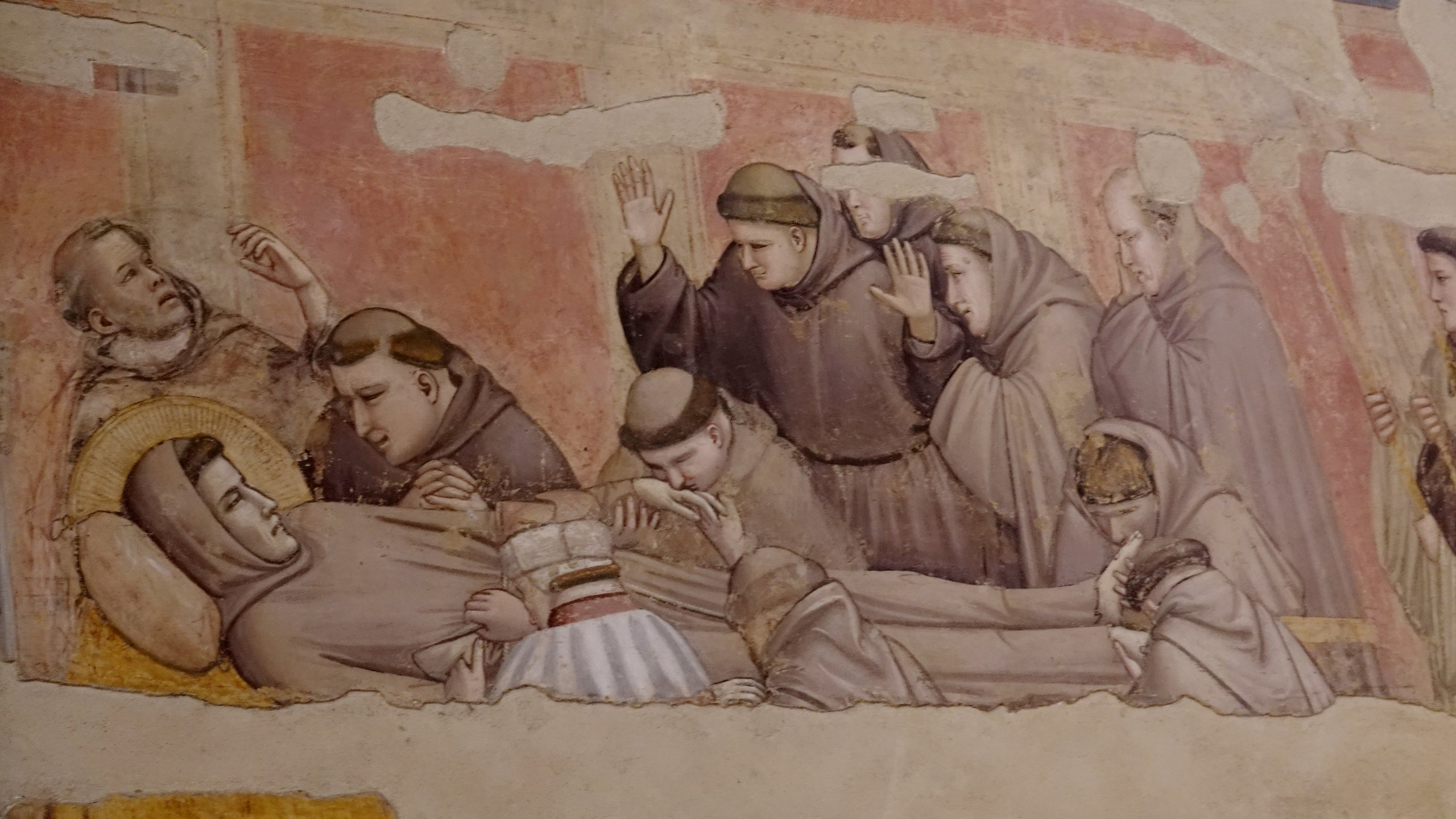 Giottos Fresko vom Tod des heiligen Franziskus: Der Heilige liegt aufgebahrt, umringt von trauernden Brüdern, die seine Hände und Füße küssen.